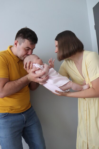 Photo maman et papa tiennent une petite fille de quatre mois.