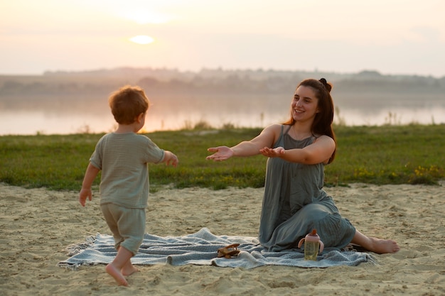 Photo maman passe du temps avec son enfant à la plage