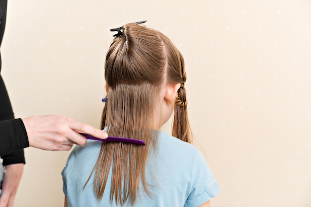 Maman peigne les cheveux mouillés de sa fille avant de les couper