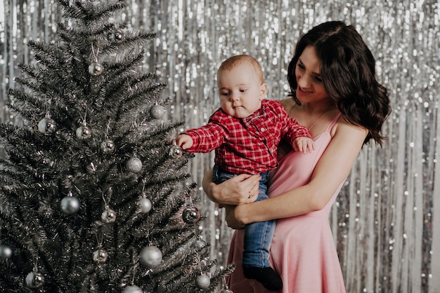 Maman et petit bébé sur fond de sapin de Noël