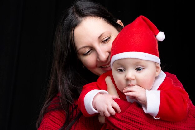 Maman et petit enfant à Noël sur fond sombre.