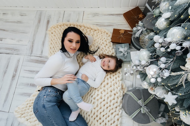 Maman avec une petite fille déballer les cadeaux. Vacance.