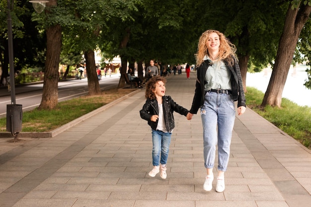 La maman et la petite fille marchent ensemble le long du front de mer