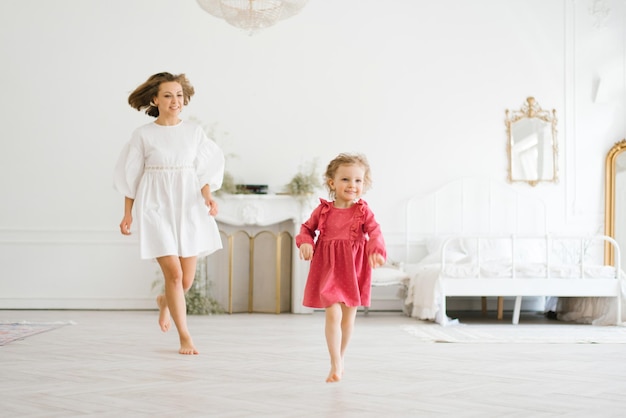 Maman et petite fille s'amusent dans le salon lumineux de la maison