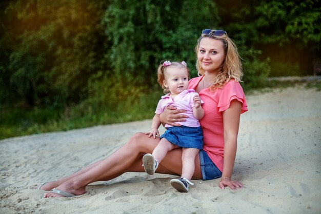 Maman et petite fille se détendre sur la plage. Le concept d'enfance, de voyage et de style de vie.