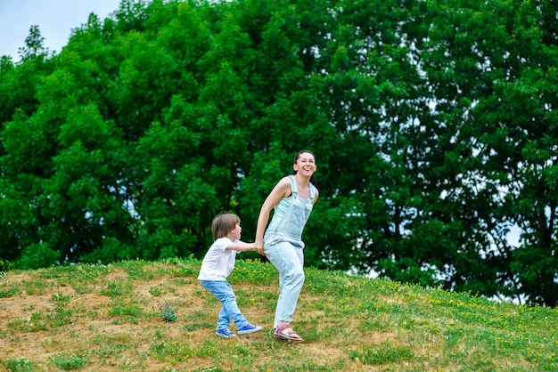 Maman qui rit joue avec son fils dans le parc