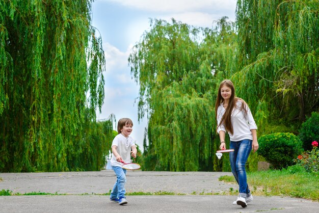 Maman qui rit roule sur le dos du petit fils dans le parc