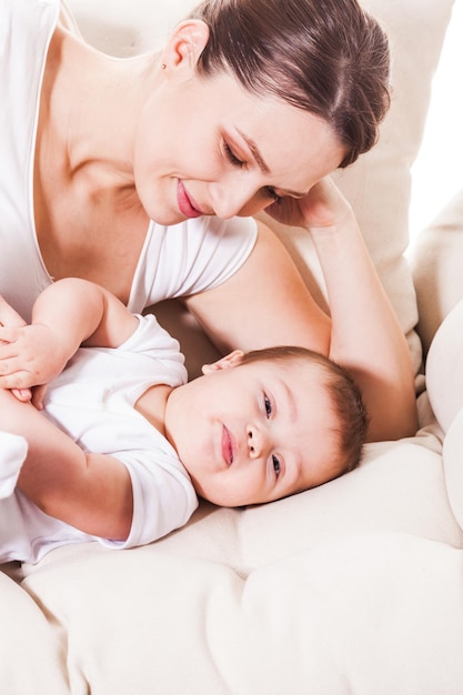 Maman regarde son mignon petit garçon sur le lit de la pépinière.