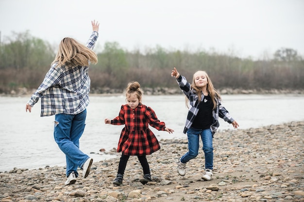 maman s'amuse et danse avec ses filles dans la nature