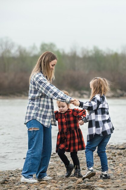 maman s'amuse et danse avec ses filles en se tenant la main