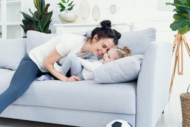 maman et sa fille allongées sur le canapé dans le salon