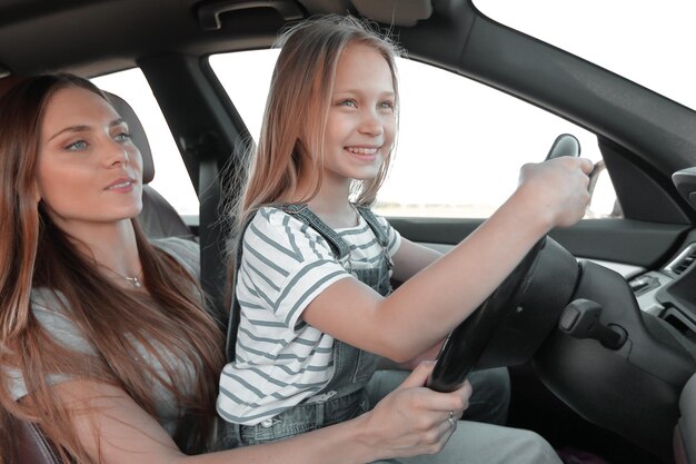 Maman et sa fille assise au volant d'une voiture