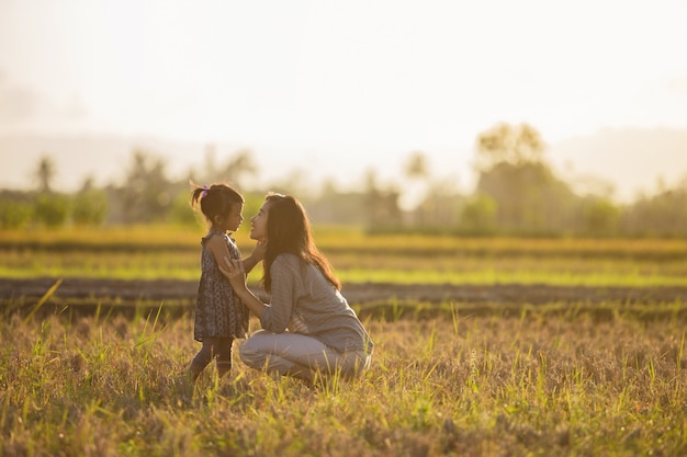 Maman et sa fille dans un magnifique paysage coucher de soleil