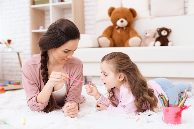 Maman et sa fille dessinent avec des feutres.