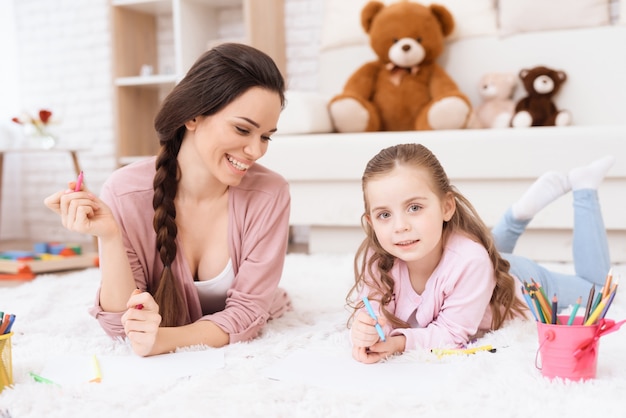 Maman et sa fille dessinent avec des feutres.