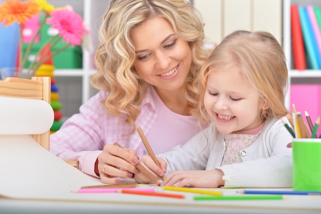 Maman et sa fille dessinent à table