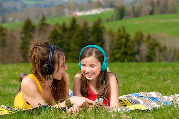 Maman et sa fille écoutant de la musique dans la nature