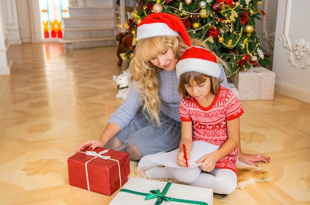 Maman et sa fille écrivent une lettre au père Noël. Mise au point sélective.