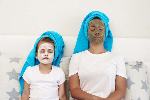 Maman avec sa fille faisant un masque à l'argile.