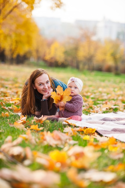 Maman et sa fille jouent dans le parc en automne.