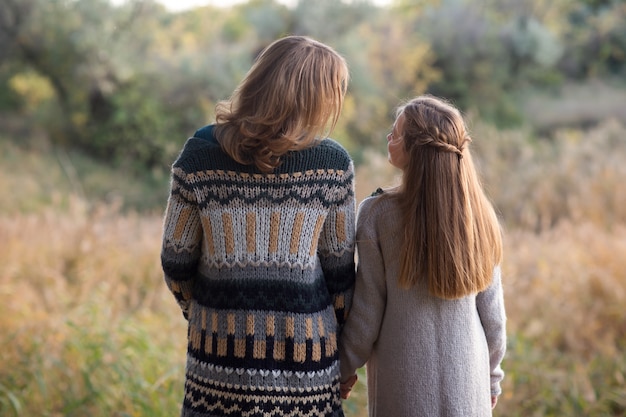 Photo maman et sa fille marchent au coucher du soleil. la nature