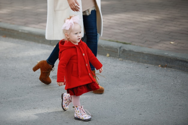 Maman et sa fille marchent le long du trottoir.