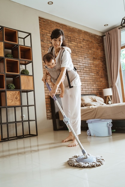 Maman et sa fille nettoient le sol de la maison