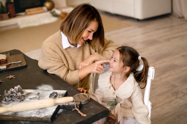 Maman et sa fille préparent des biscuits au gingembre de Noël