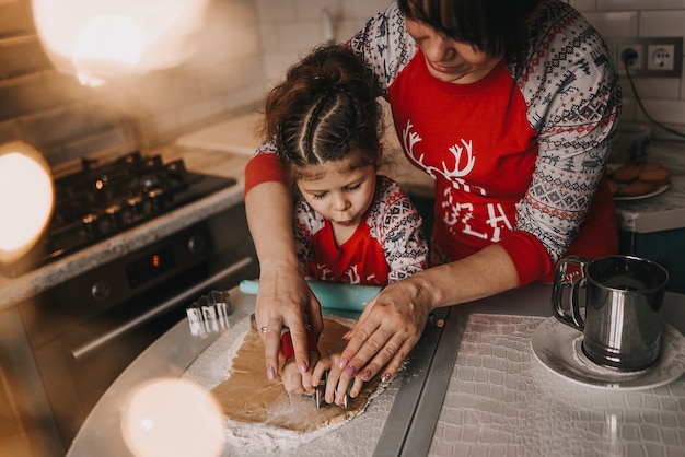 Maman et sa fille préparent des biscuits de Noël