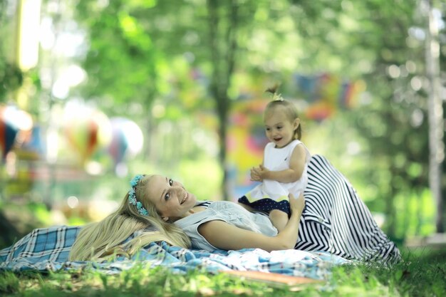 Maman et sa fille s'amusent et jouent dans le parc d'été