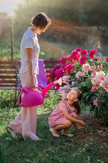 Maman et sa fille s'occupent des fleurs dans le jardin