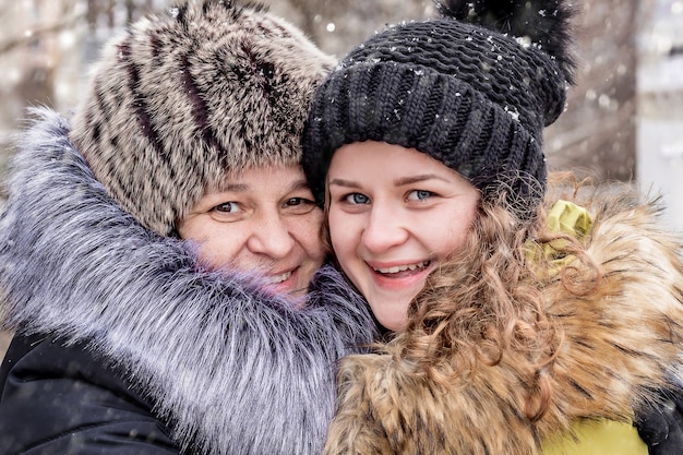 Maman et sa fille sont heureuses ensemble. Portrait de maman et fille dans la rue en hiver