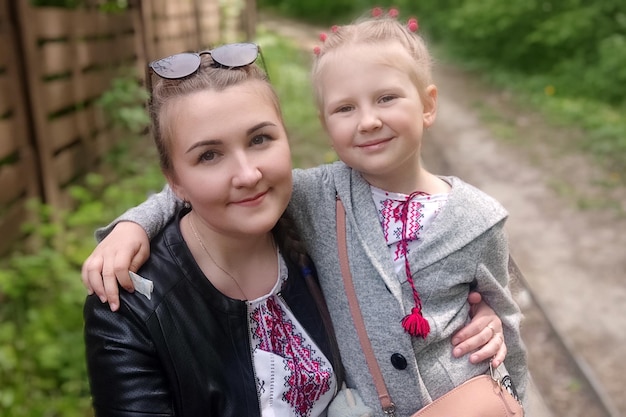 Maman et sa fille souriant dans des chemises brodées ukrainiennes tradition ukrainienne