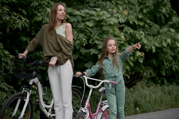 Maman et sa fille à vélo dans le parc Concept de vacances d'été pour enfants