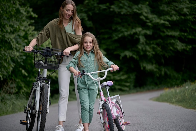 Maman et sa fille à vélo dans le parc Concept de vacances d'été pour enfants