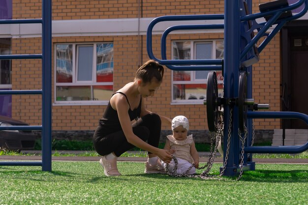 Maman et sa petite fille marchent sur le terrain de sport près de la maison