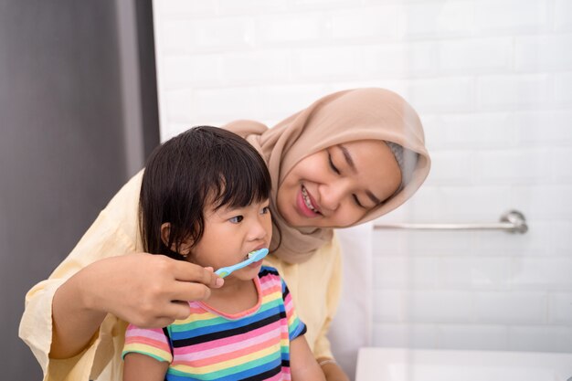 Maman se brosse les dents de son enfant