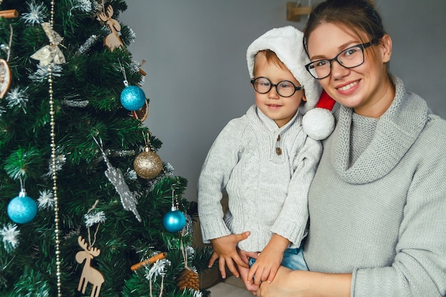 Maman et son enfant décorent ensemble le sapin de Noël