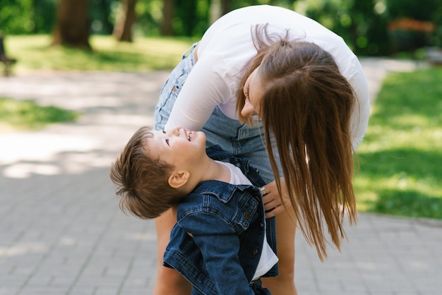 Maman et son fils jouent activement en s'amusant à l'extérieur en été dans le parc Bonne maternité enfance jeunesse Prendre soin des enfants