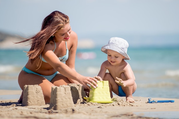 Maman et son fils jouent sur la plage