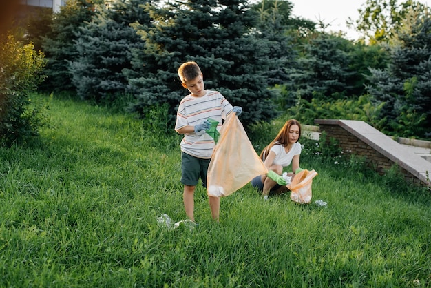 Maman et son fils nettoient les ordures dans le parc au coucher du soleil Recyclage des déchets de protection de l'environnement