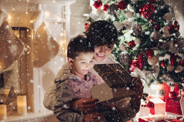 Maman et son fils ouvrent un cadeau de Noël dans une boîte