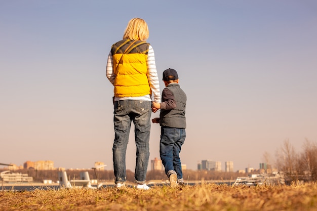 Maman et son fils se tiennent sur une colline et regardent au loin