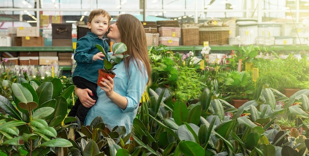 Maman et son petit garçon dans un magasin de plantes choisissent des plantes. Jardinage en serre. Jardin botanique, floriculture, concept de l'industrie horticole