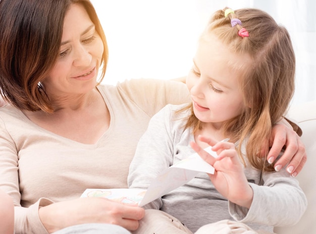 Maman souriante regardant la carte-cadeau de la fête des mères