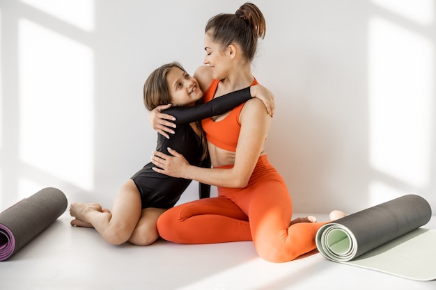 Maman sportive et petite fille en pause yoga