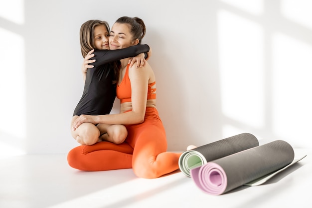 Maman sportive et petite fille en pause yoga