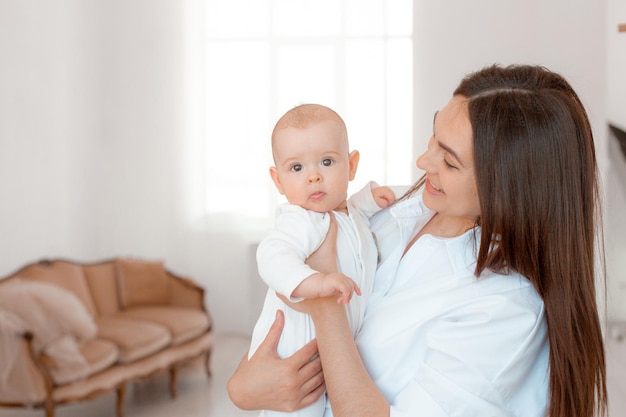 Maman tient le bébé dans ses bras à la maison