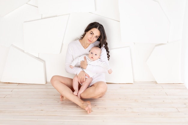 Maman tient bébé nouveau-né dans ses bras à la maison, concept de famille aimante heureuse, fête des mères