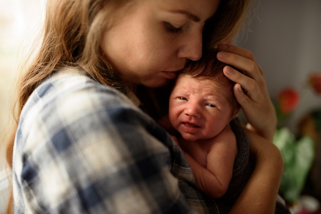 Maman tient dans ses bras son fils nouveau-né.